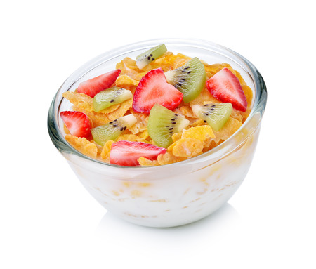 bowl of corn flakes with milk and fruit on white background.の写真素材