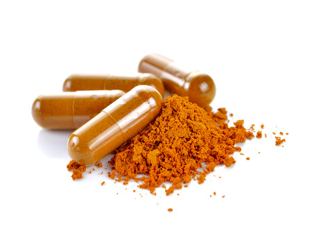 Tumeric powder capsules on white backgroundの写真素材