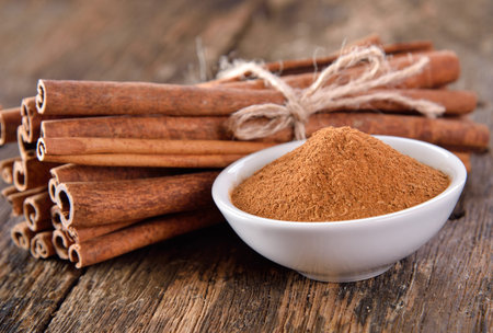 Cinnamon powder in a bowl on table wooden