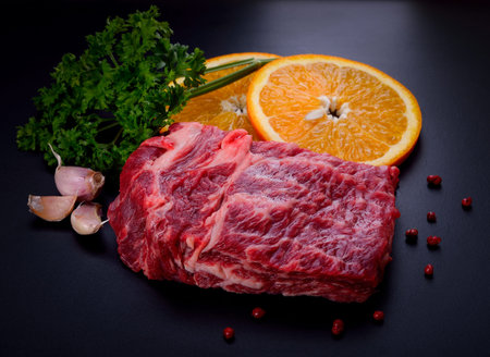 Raw beef steak with spices on black backgroundの写真素材