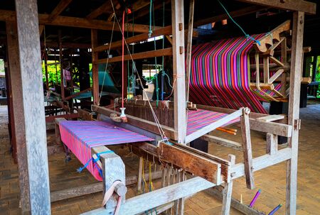 Weaving machine - Household weaving - used for weaving traditional Thai silk. Weaving loom for homemade silk or textile production in Thailandの写真素材