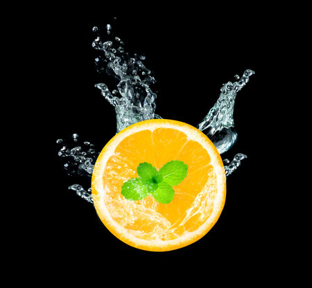 Fresh sliced orange fruit in water splash isolated on black background