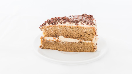 Chocolate cake slice with curl on white dish. white backgroundの写真素材