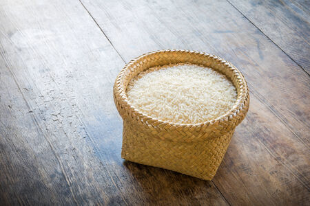 basket of jasmine rice on wooden tableの写真素材