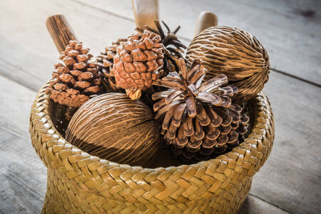 pine Cones in  Bamboo Basket on wooden tableの写真素材