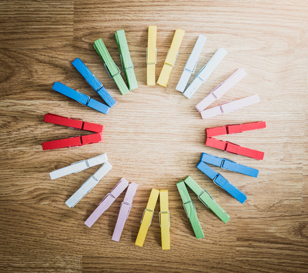 colorful wooden clothespin on wooden  background. arranged in a circleの写真素材