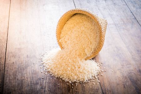basket of jasmine rice on wooden tableの写真素材