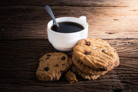 Coffee cup with chocolate cookie on dark wooden backgroundの写真素材