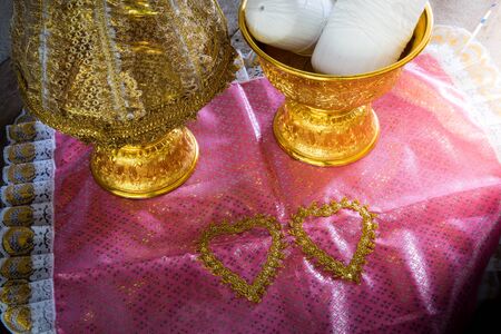 still life of Group of Thailand Gold tray with pedestal with The cover is made of lace on pink cloth. Thailand Culture Wedding Ceremonyの写真素材