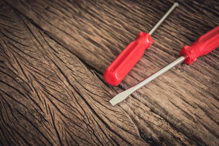 two red screwdriver on wooden backgroundの写真素材