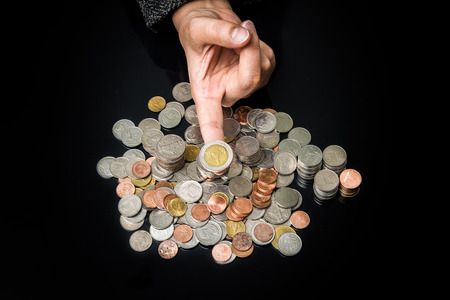 Close up of businesswoman holding coin on fingerの写真素材