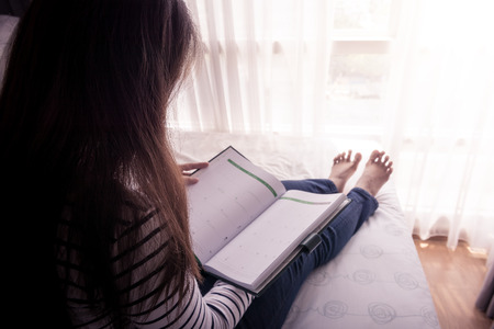 Close-up of female hands holding opened book. retro style photoの写真素材