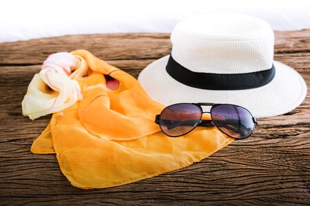 stylish hat woman sunglasses and tablet fashion scarf over wooden table. vacation and travel conceptの写真素材