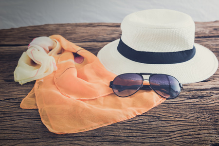 stylish hat woman sunglasses and tablet fashion scarf over wooden table. vacation and travel conceptの写真素材