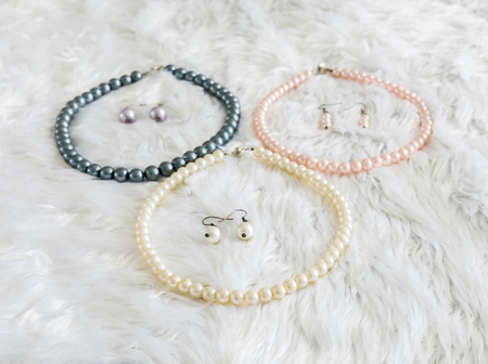 Artificial pearl necklace and earring on woollens backgroundの写真素材