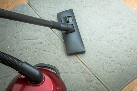 Vacuum cleaner on a gray carpet. Houseworkの写真素材