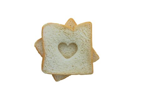 Heart shaped hole in a slice of bread isolated on white background with clipping pathの写真素材