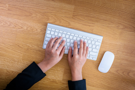Close-up of female hands working at a keyboard,computer. top viewの写真素材