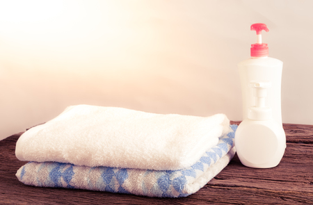 Shower gel with Skin cream and bath towels on wooden tableの写真素材