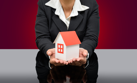 Business woman holding a model house. Home insurance conceptの写真素材