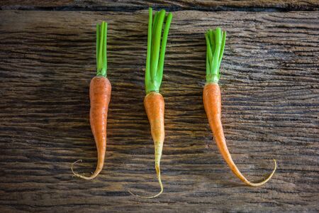 fresh carrots bunch with green leaves on wooden background Vegetable Foodの写真素材