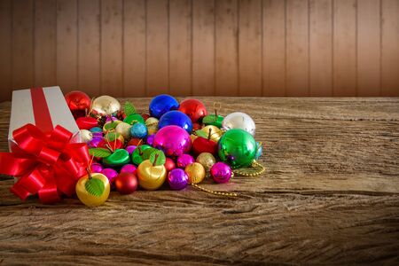 Gift box and Christmas tree ornaments. Christmas themes on wooden table with Multicolor bokeh backgroundの写真素材