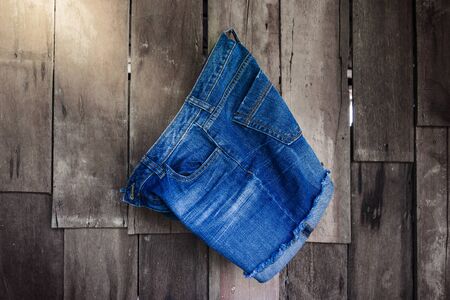 Vintage,Women's jeans shorts hanging on the wooden wall backgroundの写真素材
