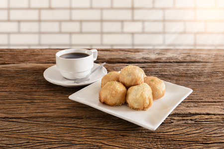 Chinese pastry moon cake with cup of coffee on wooden tableの写真素材