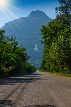 White Buddha statue on the mountain at Wat Thep Phithak Punnaram Nakhon Ratchasima Province, Thailand.の写真素材