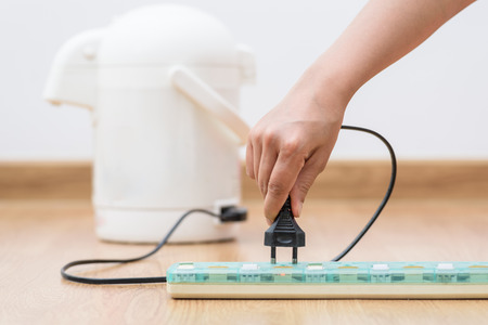 Woman unplugged plug to save on energy. Power saving conceptの写真素材