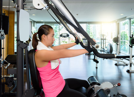 Woman at the gym working out on a Weight machine
