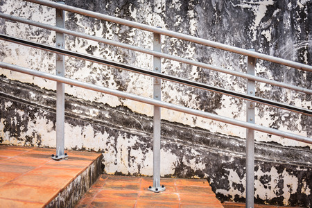 Old Steel banisters and old cement wall cracks with paint peelingの写真素材