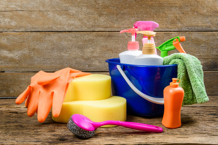 full box of cleaning supplies and gloves on wooden table backgroundの写真素材