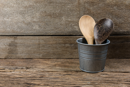 wooden kitchen set skimmer, spade of frying pan in metal box on wooden backgroundの写真素材