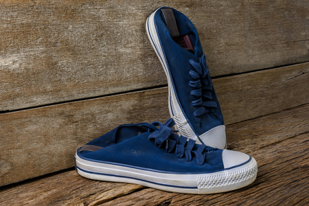 A pair of Blue canvas shoes on wooden background with copy space.  Vintage effect.の写真素材