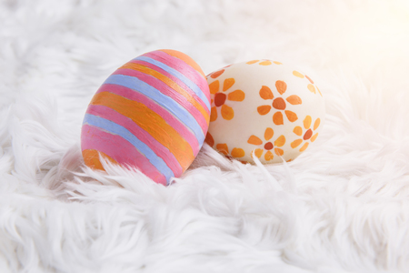 colorful handmade easter eggs on soft wool or fur background textureの写真素材