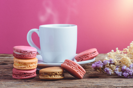 Different types color of macaroons Cup of hot tea on Old grunge wooden background Decorated with dried flowers Vintage styleの写真素材