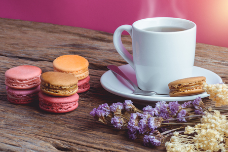 Different types color of macaroons Cup of hot tea on Old grunge wooden background Decorated with dried flowers Vintage styleの写真素材
