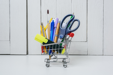 Education, Back to School, Shopping with shopping cart on table with White wooden vintage wallの写真素材