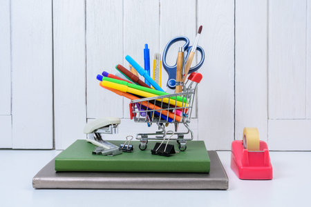 Education, Back to School, Shopping with shopping cart on table with White wooden vintage wall