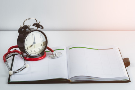 stethoscope, alarm clock and glasses on calendar book. Doctor Appointments conceptsの写真素材