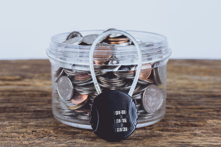 Black security lock with pass-code or password and full coins with jar. Save Money Concept and used...