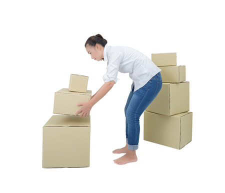 woman suffering from backache while moving boxes isolated on white background with clipping pathの写真素材