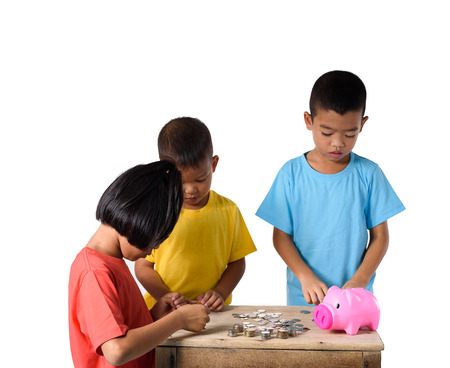 Group of asian children are helping putting coins into piggy bank isolated on white background . Education Savings conceptsの写真素材