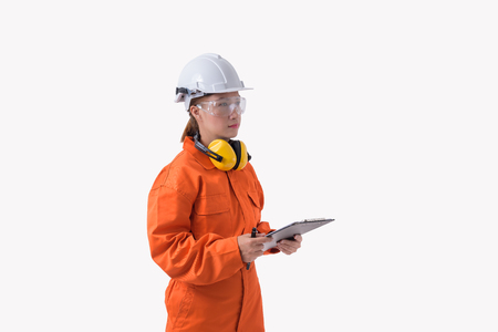 portrait of a woman worker in Mechanic Jumpsuit with helmet earmuffs and Safety goggles is holding clipboard and pen isolated on white background clipping pathの写真素材