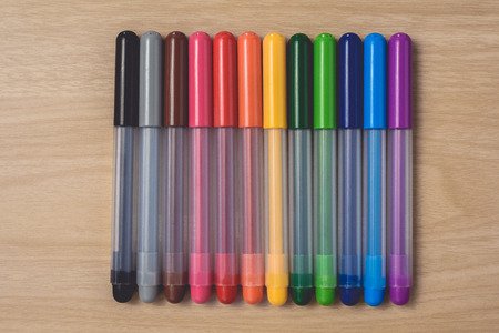 Many colorful pens on brown wood table. using for Arts and Education backgroundの写真素材