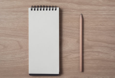 Notepad or notebook with pencil on brown wood table.using for education, business background. Take...