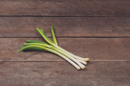 Japanese fresh green scallion or onion on wooden table background. Customize retro style images