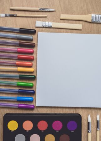 Notepad or notebook with Many colorful pens, paintbrush and Watercolor palette on brown wood table.using for Arts and Education background. Take note on book with paper and concept, copy space for your textの写真素材