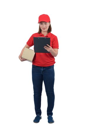 Smiling delivery woman in red uniform giving parcel boxes and clipboard, isolated on white background with clipping path. delivery service, mail, logistics, people and shipping courier service conceptの写真素材